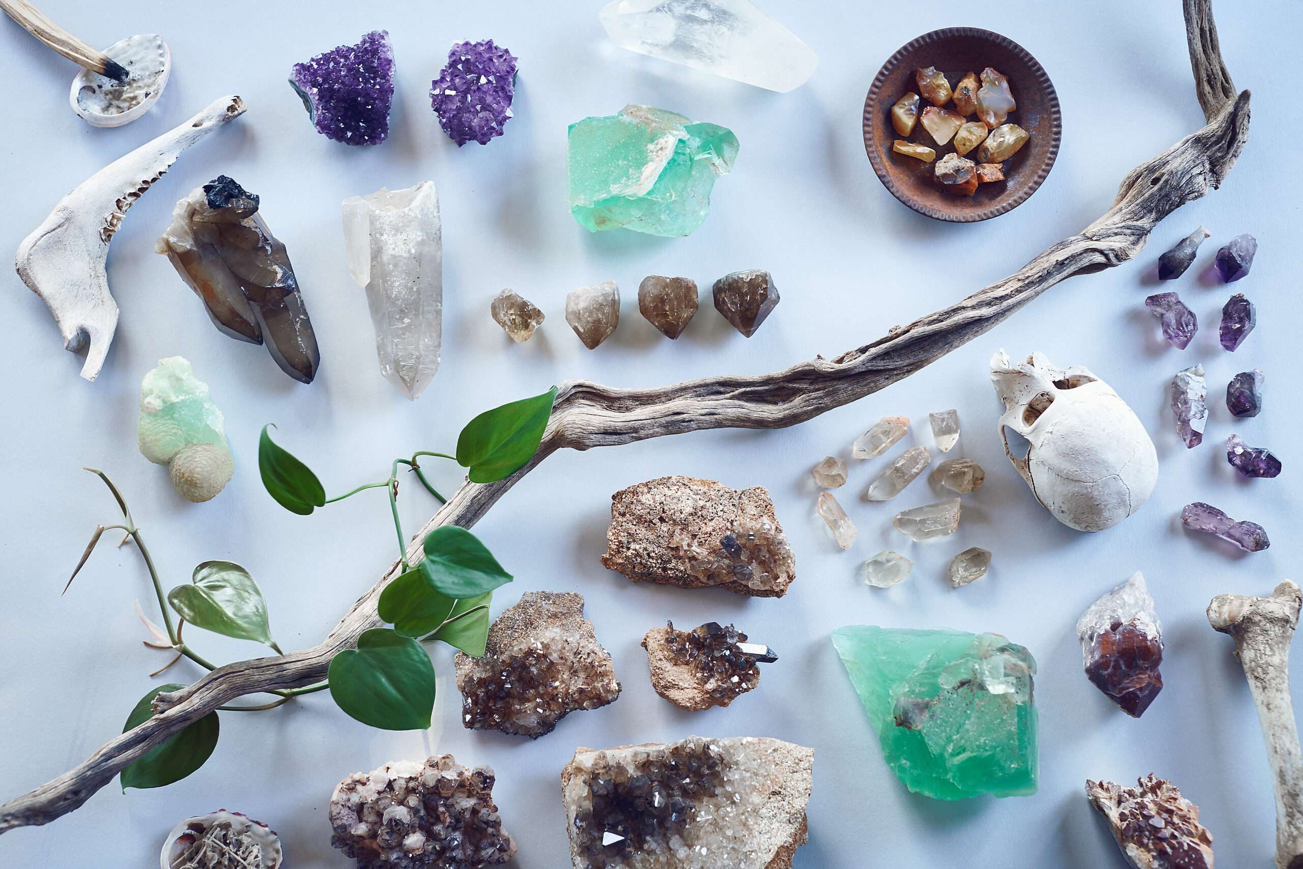 A large panoply of healing crystals for depression arranged on a glass table