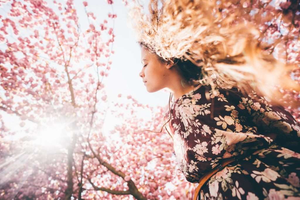 A woman with flowers blooming out of her hair: a representation of the benefits of comprehensive mental health care.